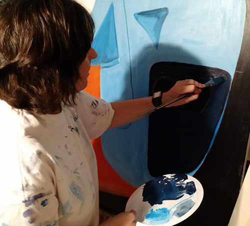 Artist Shannon Fannin working on a painting of a Ford GT40