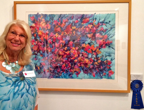 Artist Nancy Christy-Moore with her Best of Show First Place “Blooms and Butterflies” Mixed Water Media and Rice Paper Collage on Paper (framed), 30” x 39” by artist Nancy Christy-Moore. See her portfolio by visiting www.ArtsyShark.com