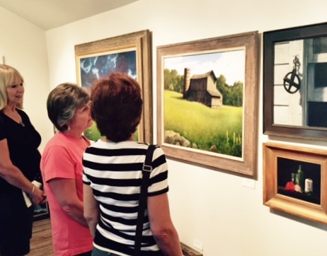 Shoppers at an art gallery. Read how artists can partner with galleries to sell work more effectively at www.ArtsyShark.com