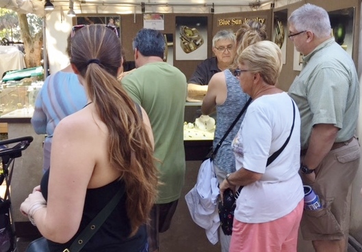 Customers shop at an art festival.