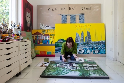 Artist Clare Haxby in her studio with architectural paintings by artist Clare Haxby. See her portfolio by visiting www.ArtsyShark.com