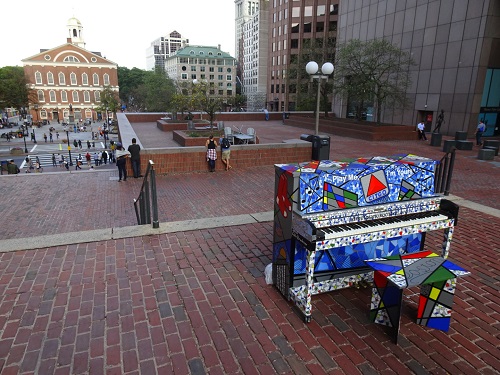 “Play Me, I’m Yours, Boston” Mixed Media, Acrylic and Paper on a Piano, 61” x 49” x 25” by artist Eddie Bruckner. See his portfolio by visiting www.ArtsyShark.com