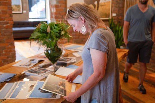 A gallery visitors shops for prints.