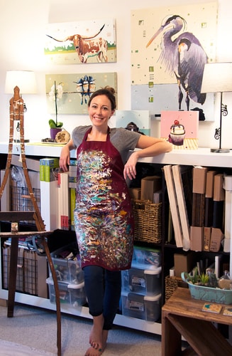 Artist Nikkie Markle in her studio with some of her whimsical animal paintings