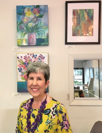 Artist Susan Hurwich poses with a display of artwork