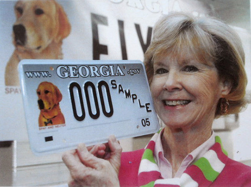 Artist Carolyn Ritter holding the Georgia license plate featuring her art