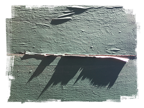 “The Shadow Knows” (West 29th Street, New York City) Photograph of a gray painted wood slat wall with paper stuck between the slats by Denise Solay