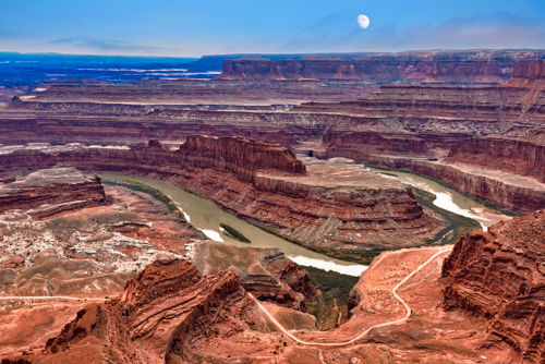 Photograph of a daytime moon over Deadhorse Point in Utah, a bend in the Colorado River by Andy Crawford