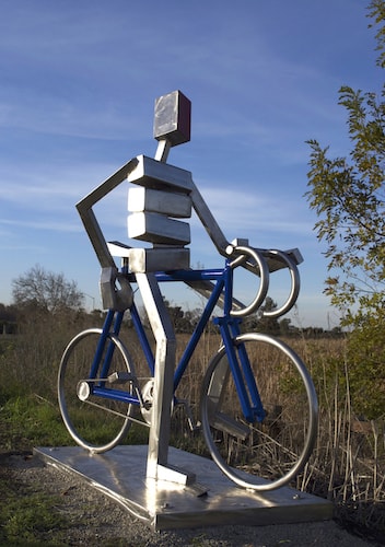 Abstract Stainless steel sculpture of a figure on a bike by James Moore