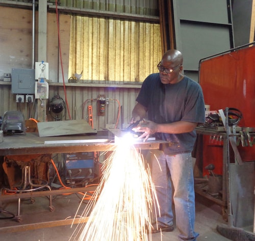 Artist James Moore welding a sculpture in his studio
