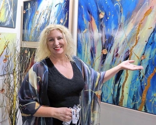 Artist Victoria Velozo with her paintings
