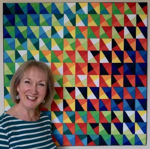 Artist Alexandra Kingswell in front of one of her abstract patterned fiber art pieces