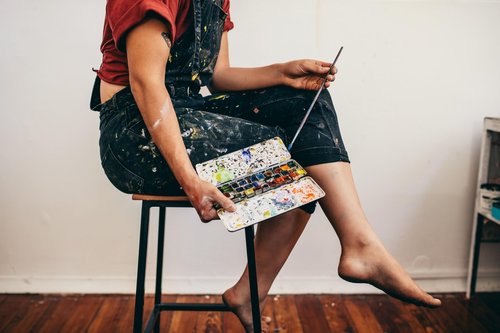 Artist holding watercolor paint set