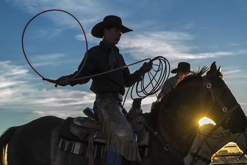 Photograph of a young cowboy learning how to rope by Christopher Marona