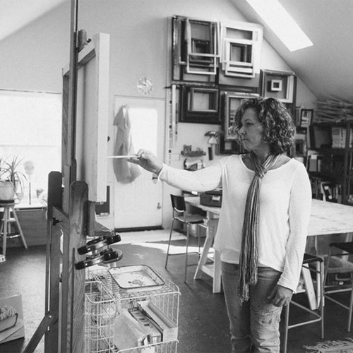 Artist working at an easel in her studio