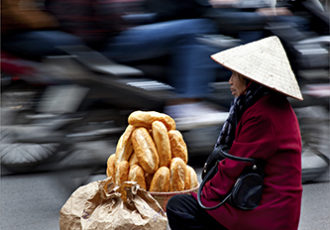 Digital Photograph of a Vietnamese woman selling baguettes by Robert Dodge
