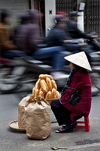Digital Photograph of a Vietnamese woman selling baguettes by Robert Dodge