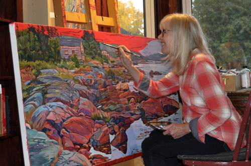Artist Janet MacKay painting in her studio