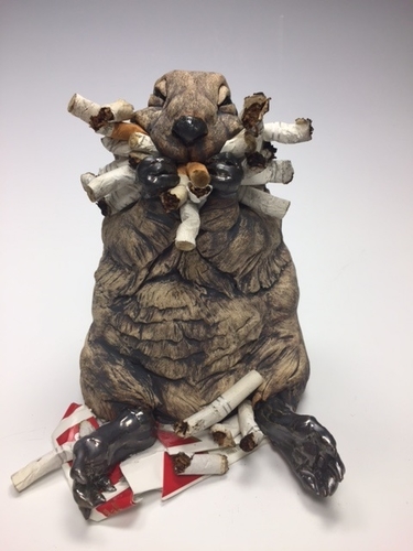 Stoneware and found object sculpture of a ground hog with him mouth full of cigarette butts by Deana Bada Maloney