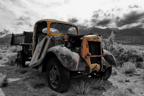 Black & white and color photograph of an old car in front of the Sangre de Cristo Mtns. by Dave Maes