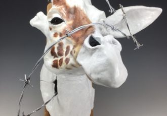 Stoneware and mixed media sculpture of a giraffe's head caught in barbed wire by Deana Bada Mahoney