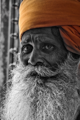 Black & white photograph with color of a doorman in India by Dave Maes