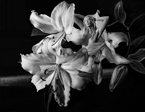 Black and White photograph of a sculpture of a female nude and flowers by Bonnie Kamhi