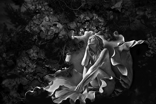 Black and White photograph of a sculpture of a female nude and flowers by Bonnie Kamhi