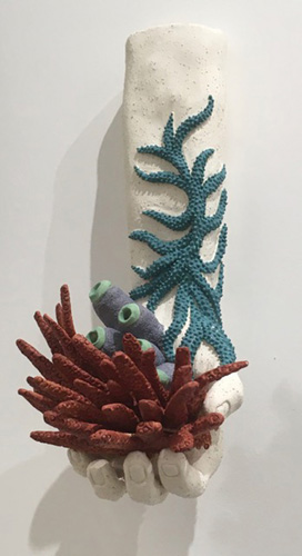 ceramic sculpture of hand with coral showing effect of climate change