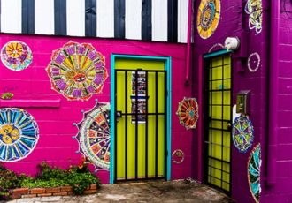 Photograph of a yellow door on a pink building in New Orleans by Jenny Nordstrom