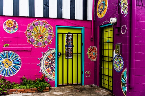 Photograph of a yellow door on a pink building in New Orleans by Jenny Nordstrom