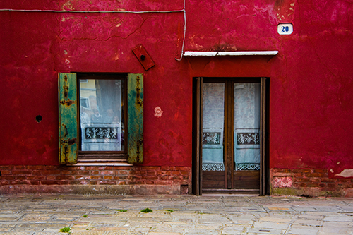Photograph of a red lacy door in Murano, Italy by Jenny Nordstrom