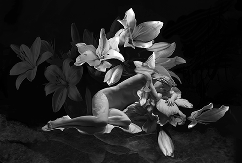 Black and White photograph of a sculpture of a female nude and flowers by Bonnie Kamhi