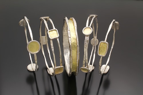 five handmade silver and gold bangle bracelets by Sana Doumet