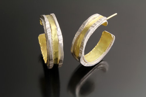 a pair of hand made silver and gold hoop earrings by Sana Doumet