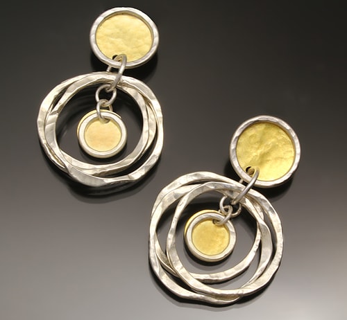 a pair of hand made silver and gold dangle earrings by Sana Doumet