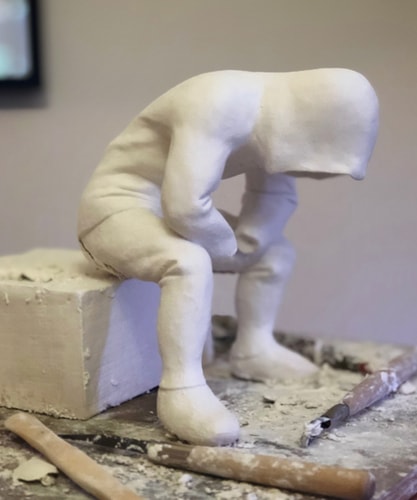 white hoodied figurative sculpture of a man deep in thought by Rob Lenihan