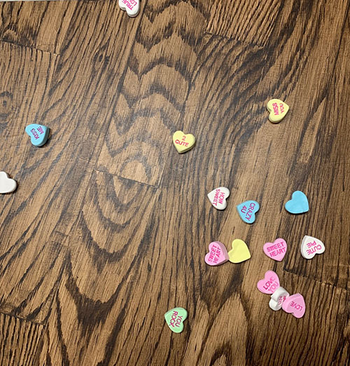 mixed media painting of conversation hearts on a wood floor by Roberta Lynn Rose