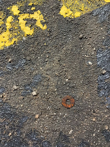 mixed media painting of a rusted washer on pavement by Roberta Lynn Rose