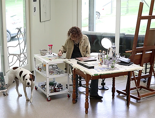 Artist Sudie Rakusin at work in her studio with her dog Marmie