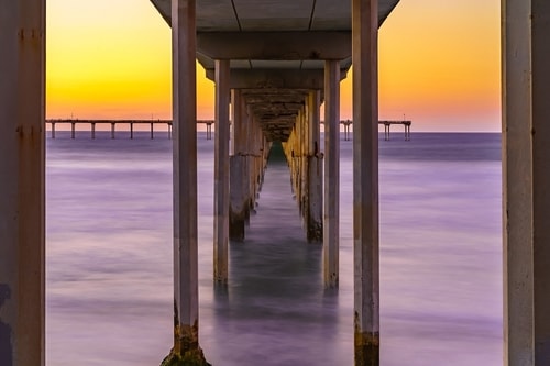 photograph through a pier at Ocean Beach, San Diego, CA by Brian McClean