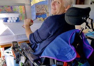 Teraplegic artist Alder Crocker paints using a special table in his studio