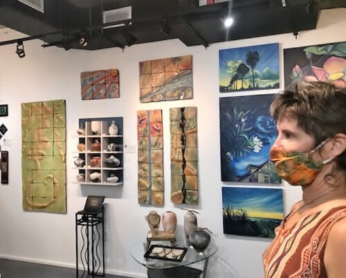 Masked artist in her gallery space