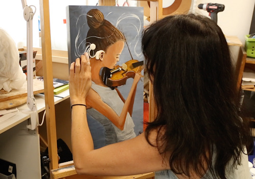 Artist Priscila Soares painting a violinist