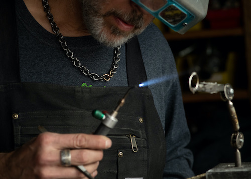 Artist Tony Finocchio soldering jump rings for a chain