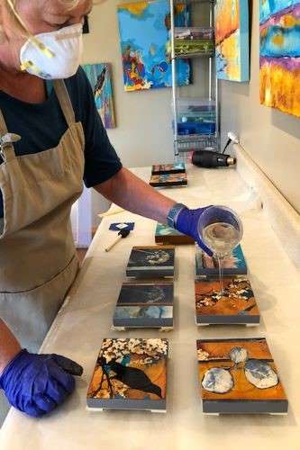 Artist P.K. Williams in her studio pouring epoxy resin