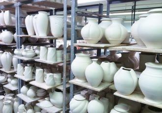 shelves of greenware in production pottery studio