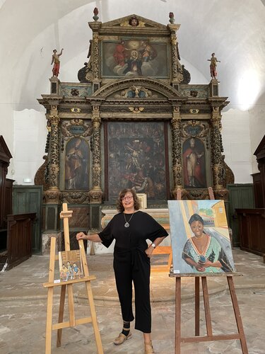 Artist Susan Brown with artwork in an exhibition in France.