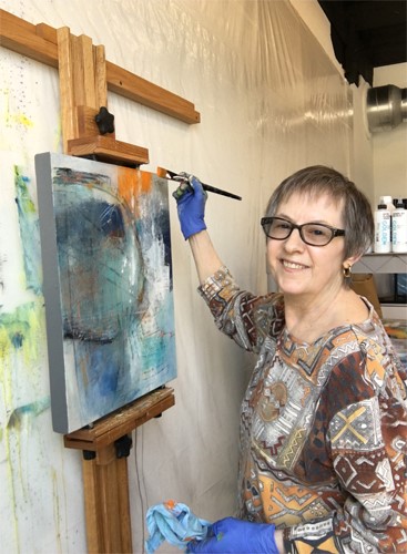 Artist Lee Muslin painting in her studio