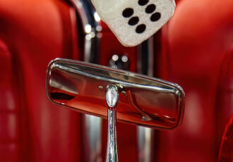 Close up photo of dice in a vintage car windshield